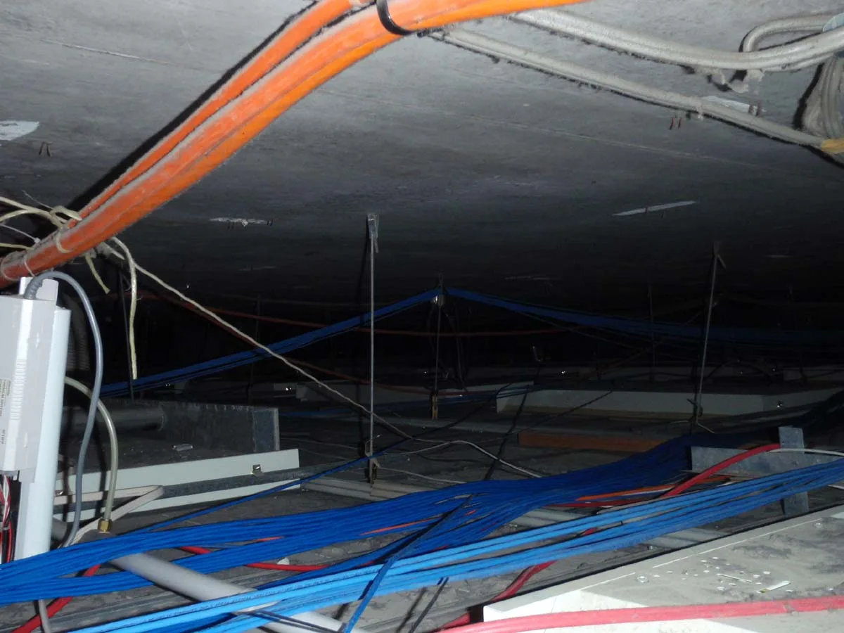 Heavy dust accumulation on cable trays in data centre ceiling void